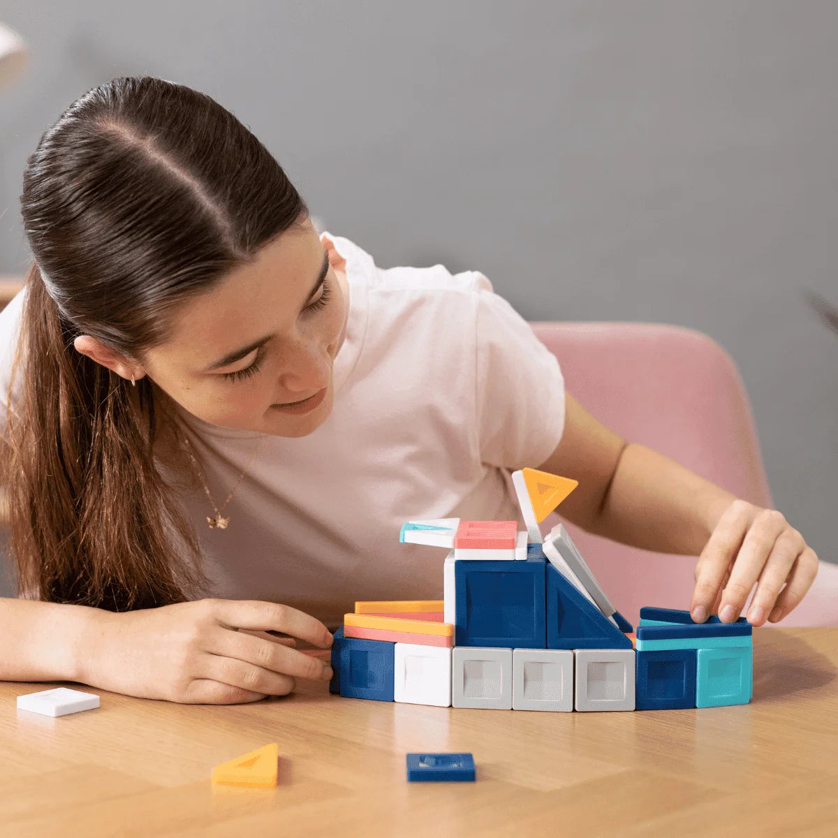 Junge Frau spielt mit bunten Magnetbausteinen im PRO Constructor Set 70 Stk