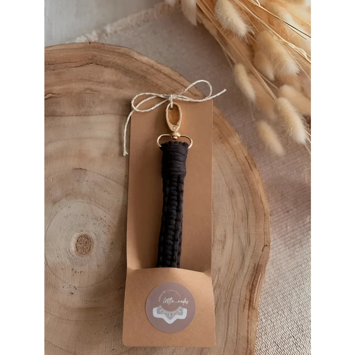Holzpaddle mit dunklem Griff und Logo, passend zum Makramee Schlüsselanhänger LOOP