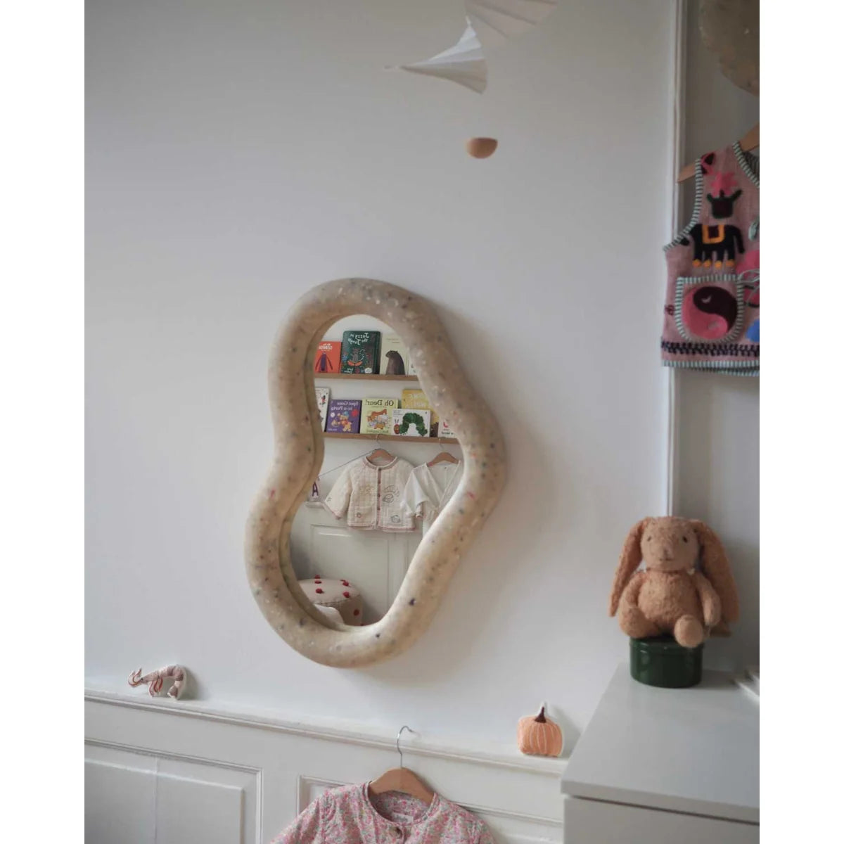 Ein beige organisch geformter marine spiegel mit strukturierter gesprenkelter rahmen in faded-white farbe
