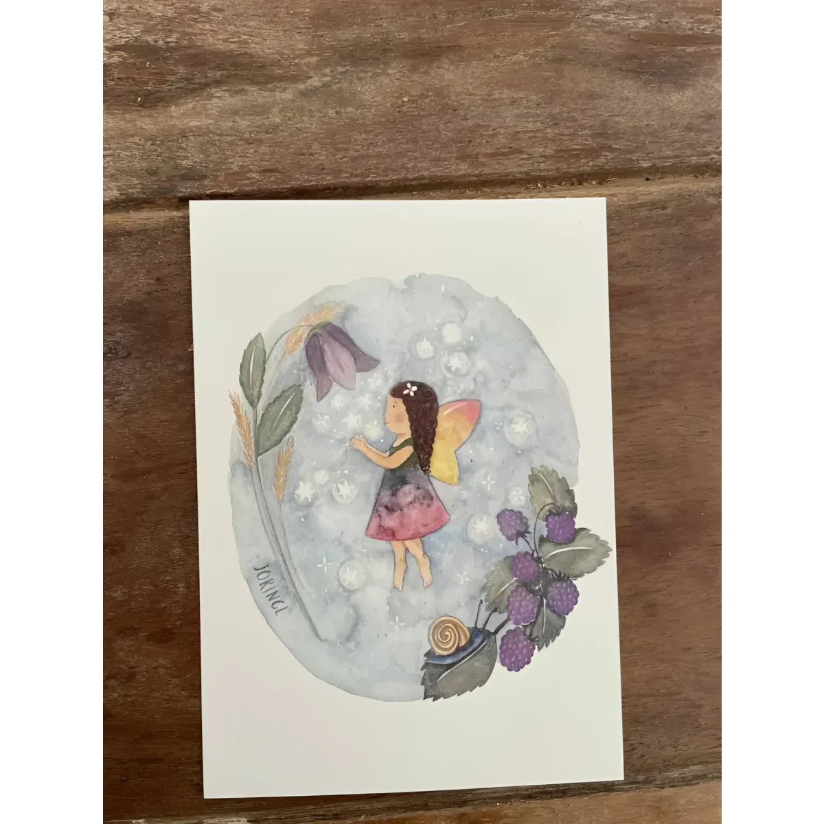 Eine delicate aquarellkarte mit einer fee in gelben flügeln und rosa kleid umgeben von beeren und blättern für geschenke