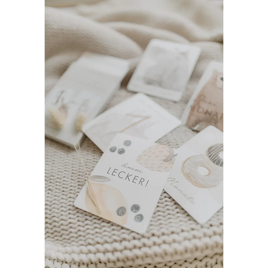 Eine weiße papieranhänger mit pastellfarbenen donuts und beeren für nachhaltige babykleidung schweiz geschenke