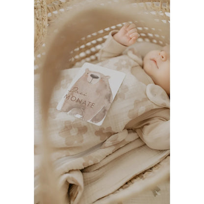 Beige babyonesie mit zartem blumenmuster und gerafftenärmeln aus atmungsaktivem stoff für nachhaltige babykleidung schweiz