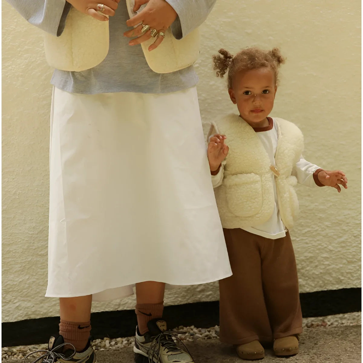 Creamfarbige, kuschelige merino mama gilet aus schaffell mit frontverschluss und zwei seitentaschen für nachhaltige