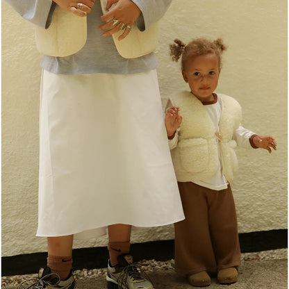Creamfarbige, kuschelige merino mama gilet aus schaffell mit frontverschluss und zwei seitentaschen für nachhaltige