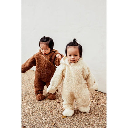 Zwei Kleinkinder in flauschigen Einteiler-Outfits von Merino Snugglesuit Bruno