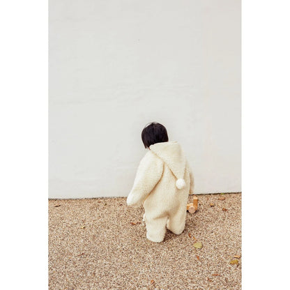 Person im flauschigen weißen Onesie von hinten, Merino Snugglesuit in Milchfarbe