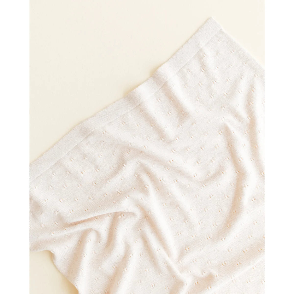 Weißer Stoff mit sanften Falten der Merino Strickdecke Bibi in Creme