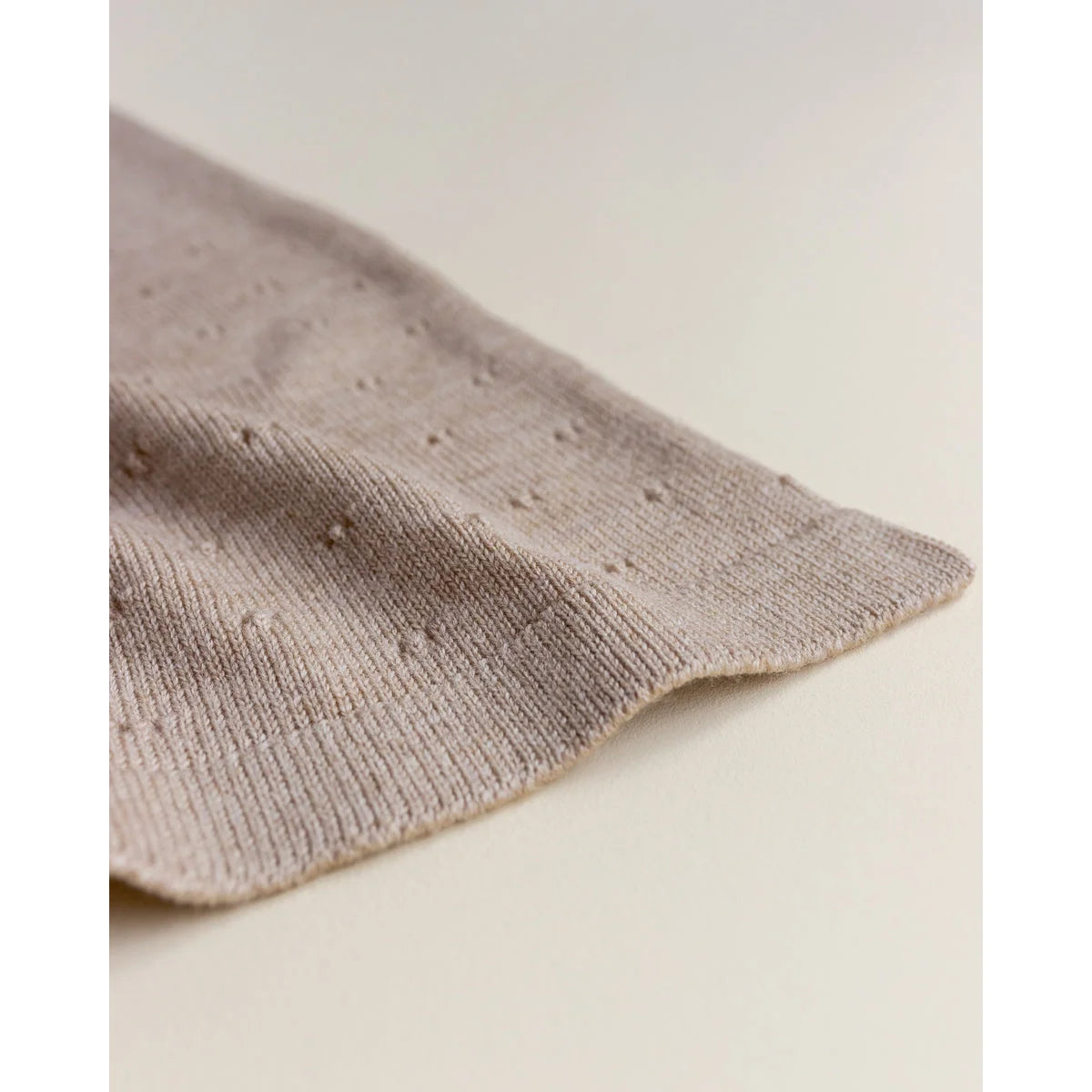 Beige gestrickter Stoff mit kleinen Erhöhungen für die Merino Strickdecke Bibi