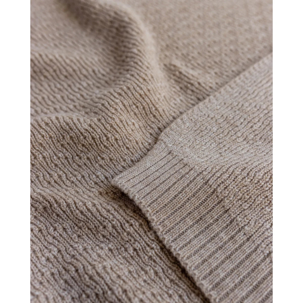 Beige gestrickter Stoff mit gerippter Textur und sichtbarem Naht der Merino Strickdecke Dora
