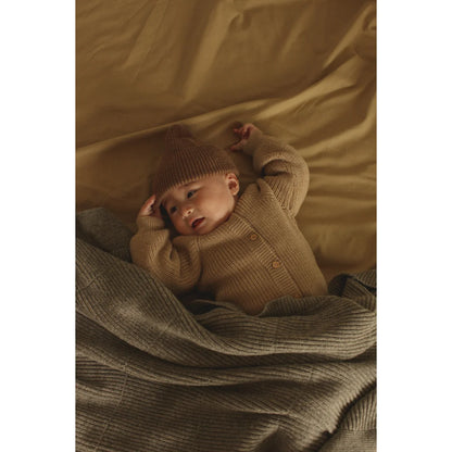 Baby schläft in einer gemütlichen Strickdecke Gaston aus Merinowolle