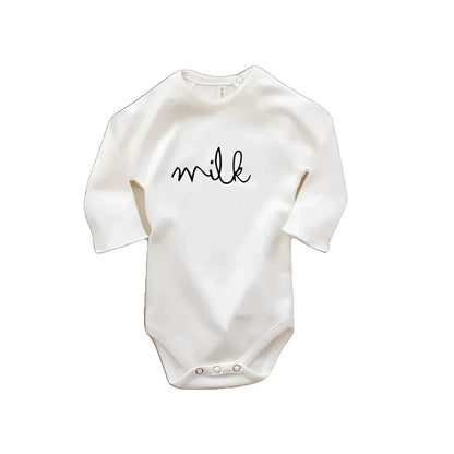 Weiße Baby-Bodys mit Milch in geschwungener Schrift auf der Vorderseite