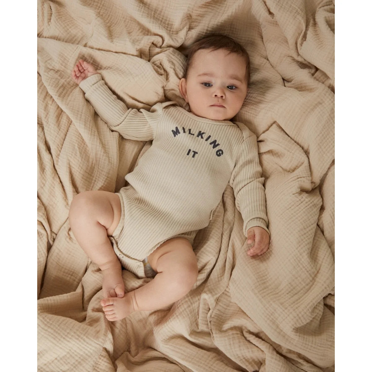 Beiges geripptes Baby-Langarmbody aus Baumwolle mit Milking It® Aufdruck in Dunkelgrau