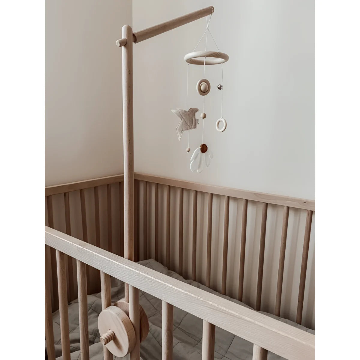 Holz-Kinderbett mit Mobile Daisy Daylight in Beige darüber hängend