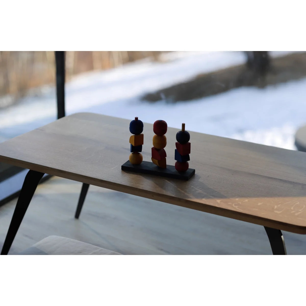 Modern stacking toy Y mit drei bunten geometrischen holzfiguren auf schwarzer basis ideal für ökologische