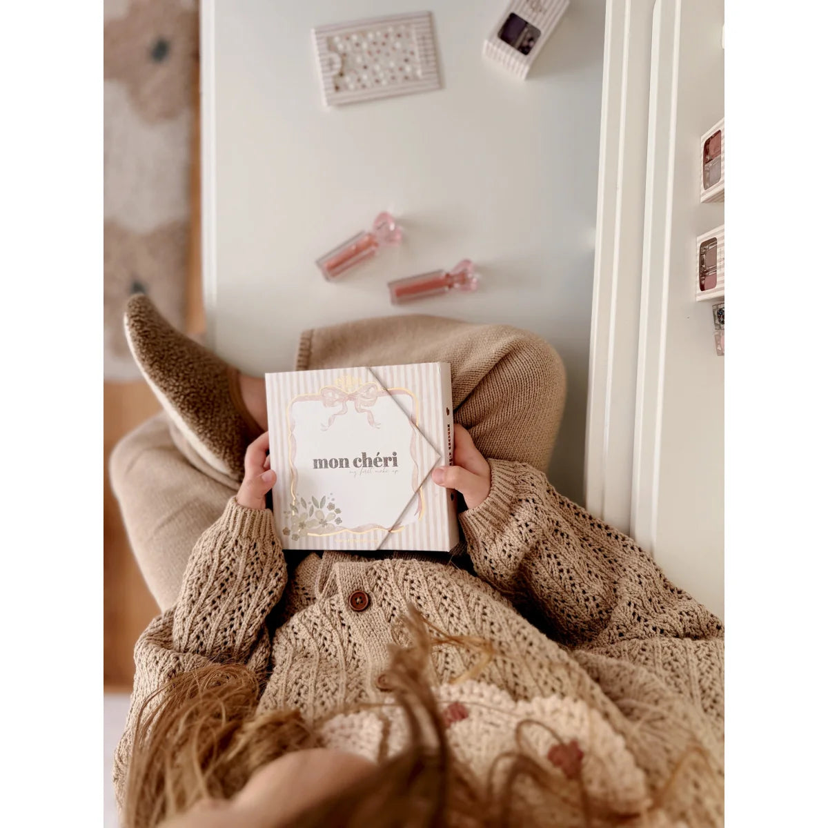 Ein weiß-beige gestreiftes rechteckiges mon chéri make-up-set mit floralem design für ökologische baby- & kinderprodukte