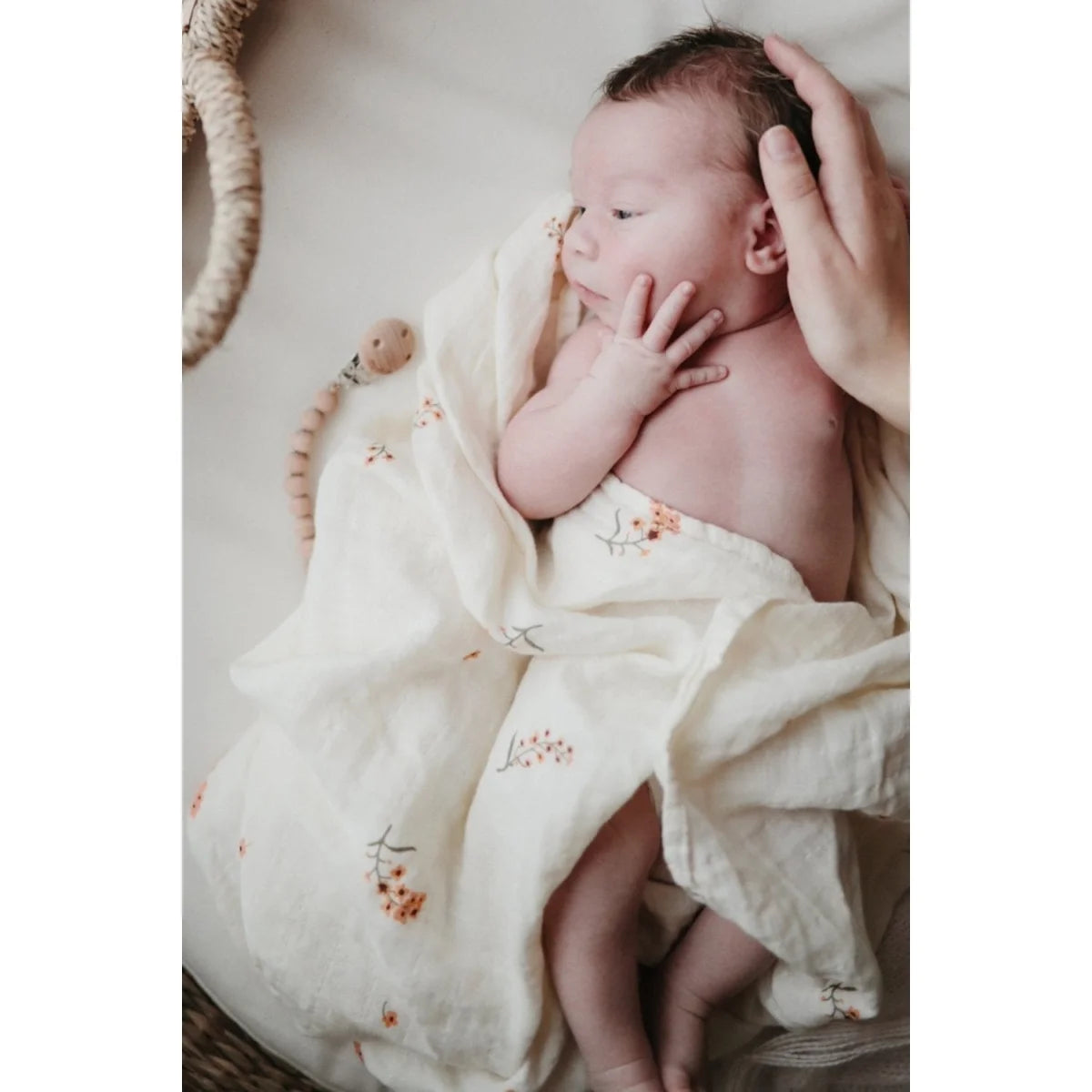 Neugeborenes Baby in einem floralen Muster gewickelt mit Mulltuch Flower