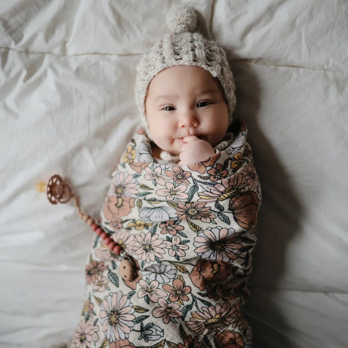 Baby in Floral Swaddle and Knitted Hat from Mulltuch Retro Flowers Collection