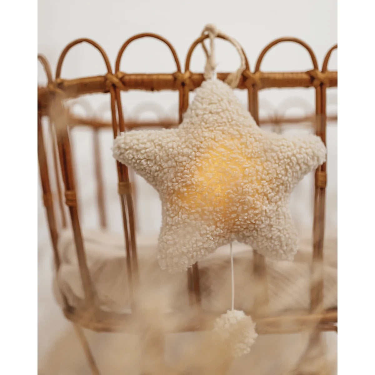 Fluffy sternförmige Ornament mit sanftem Glühen, hängend an geschwungener Struktur