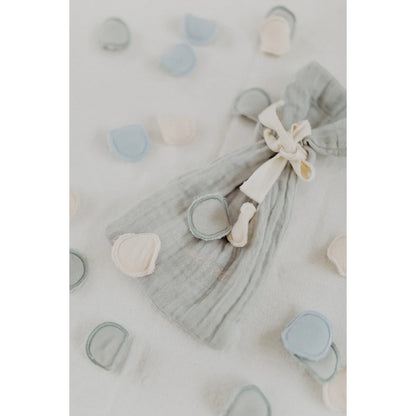 Ein weicher grauer gauze ziehbeutel mit cremefarbenem band und stoffknöpfen für nachhaltige babykleidung schweiz
