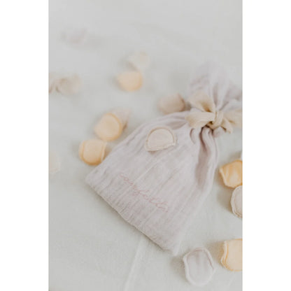 Ein zarter offwhite muslin konfetti beutel mit rosa stickerei und gerafftem top für ökologische baby- und kinderprodukte