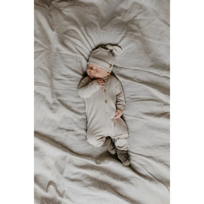 Schlafendes Baby in beiger Kleidung mit Newbie Hut in Beige