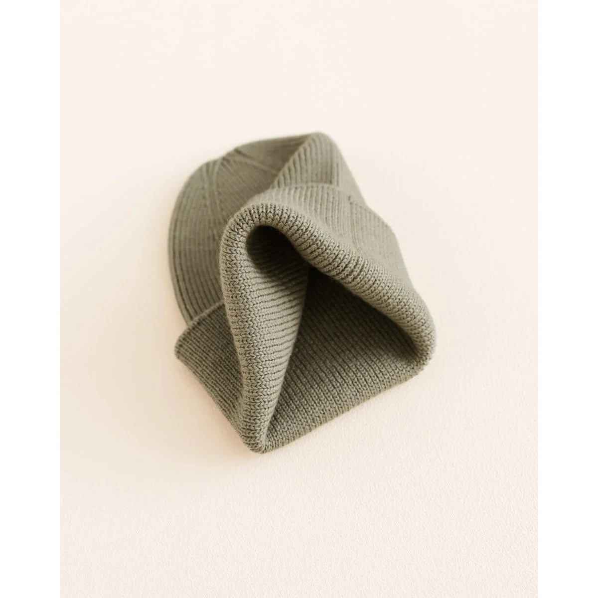 Sagegrüner Beanie Fonzie aus ökologische Kinderbekleidung, gefaltet für Neugeborene