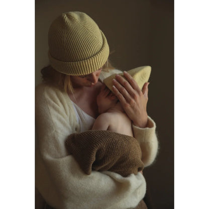 Person mit gelber Strickmütze hält Baby im Newborn Beanie Fonzie in Hellgelb