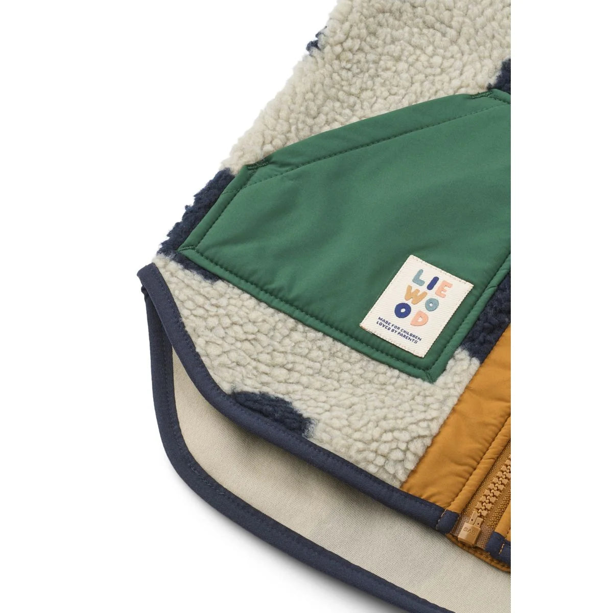 Cozy noam pile vest in cream shearling with forest green nylon and mustard yellow patches with navy blue trim
