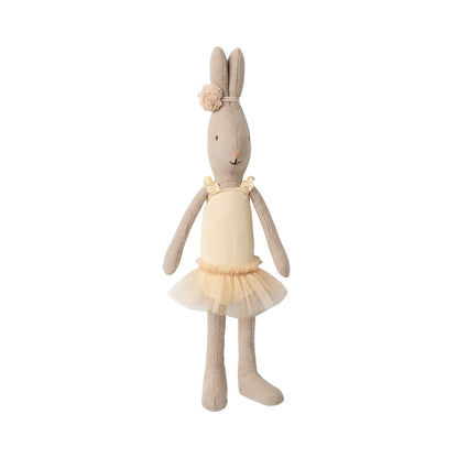 Eine weiche, beigefarbene Plüschkaninchenpuppe, gekleidet in ein zartes, cremefarbenes Ballett-Outfit mit einem gerafften