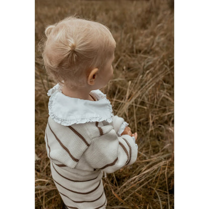 Blondes Kleinkind in gestreiftem Pullover steht auf einem Feld für Oversize Knit Pullover Stripe