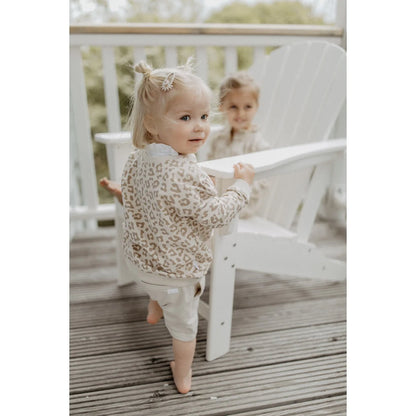 Ein kleinkind trägt einen beige leo oversize pullover aus nachhaltiger babykleidung schweiz passend als geschenk