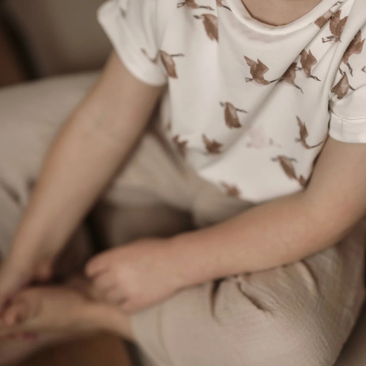 Oversized Shirt von Goose mit Vogelmustern und beigen Hosen im Bild