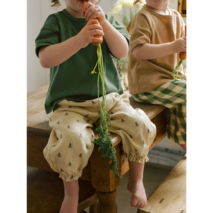 Kind mit grünem T-Shirt, beiger Hose mit Anker-Prints, Lavender Bloom Gardener