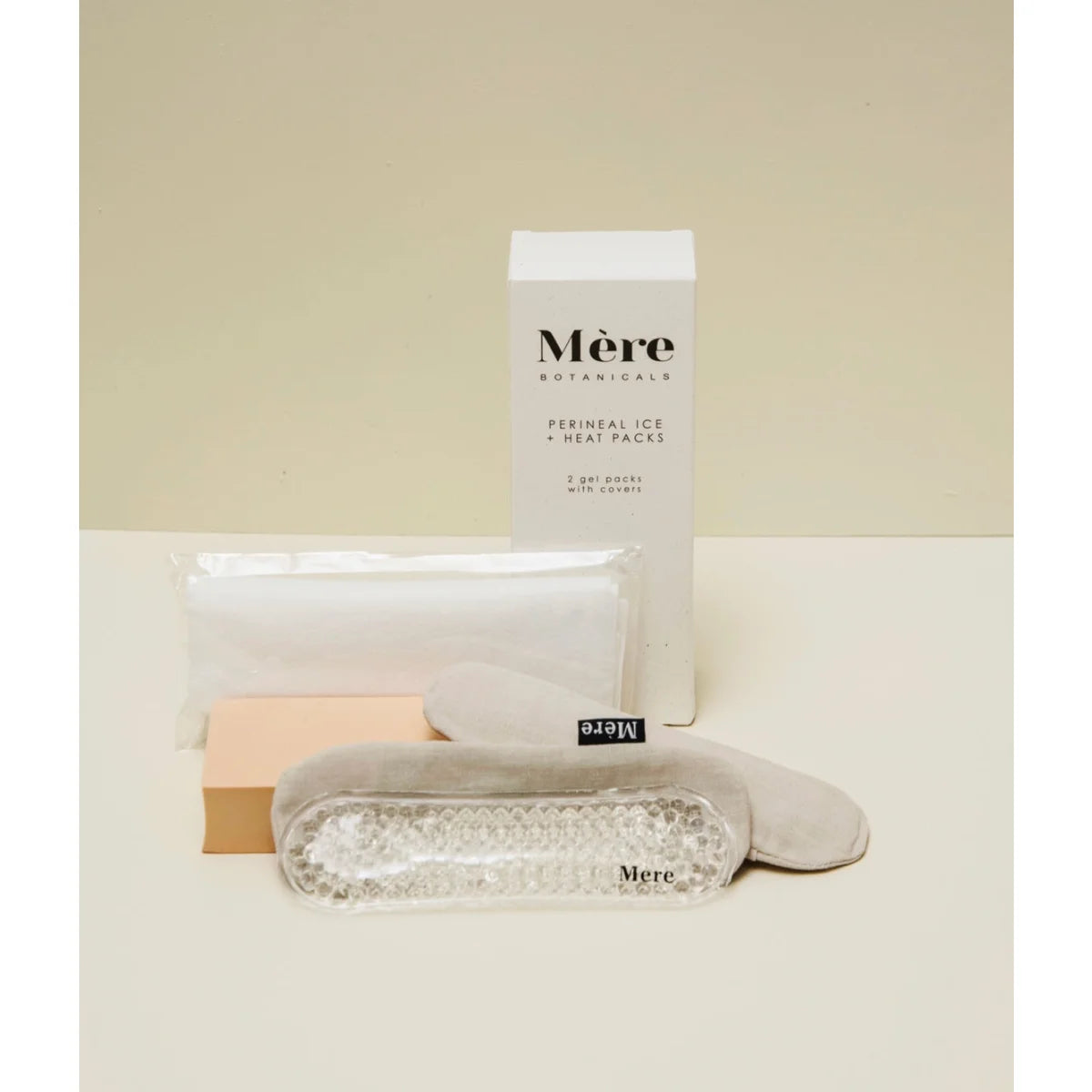 Minimalistische Hautpflegeprodukte in einer weißen Schale neben Perineal Ice + Heat Packs