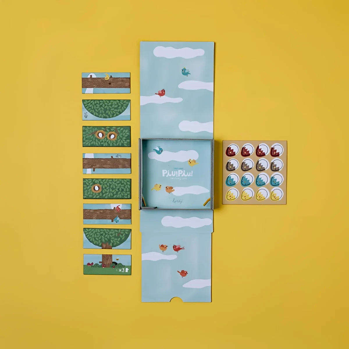PIU PIU Tiny Game: Bunte Vogel-Aufkleber auf Puzzle-Box mit Himmel-Design