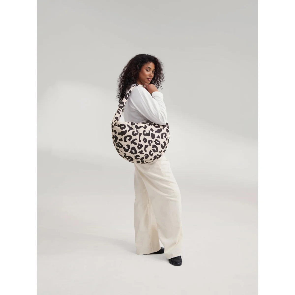 Puffy cross body bag mit weichem rundem design und schwarz-cremefarbenem leopardmuster ideal für ökologische