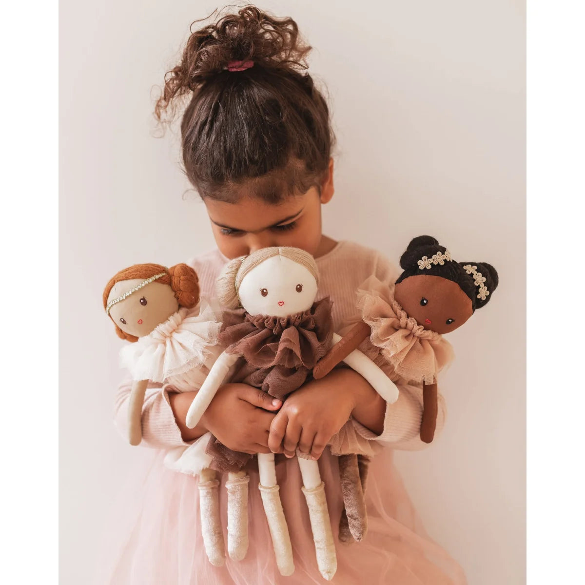 Kind hält drei diverse Stoffpuppen von Puppe Dollies | Maggie Lu