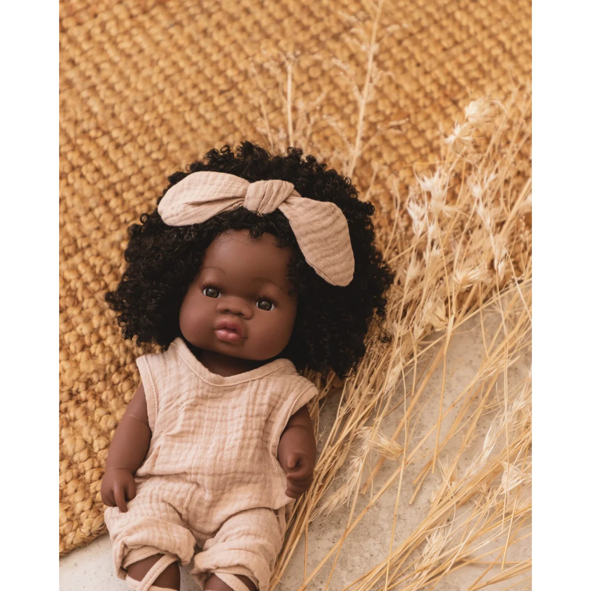 Puppe Loreta mit dunkler Haut, lockigem Haar und beigem Outfit
