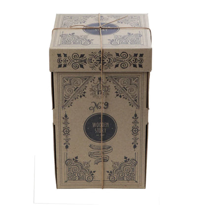 Ein beiger karton mit schwarzen ornamenten und holz story label als verpackung für nachhaltige babykleidung schweiz geschenke