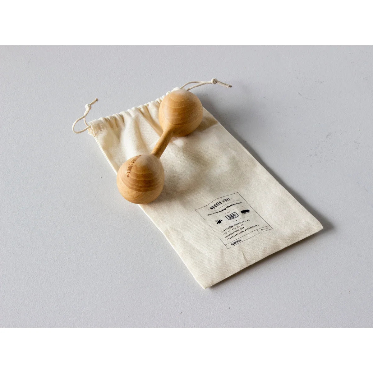 Two light wooden maracas resting on a cream canvas bag from rassel lark ideal for ökologische baby- & kinderprodukte