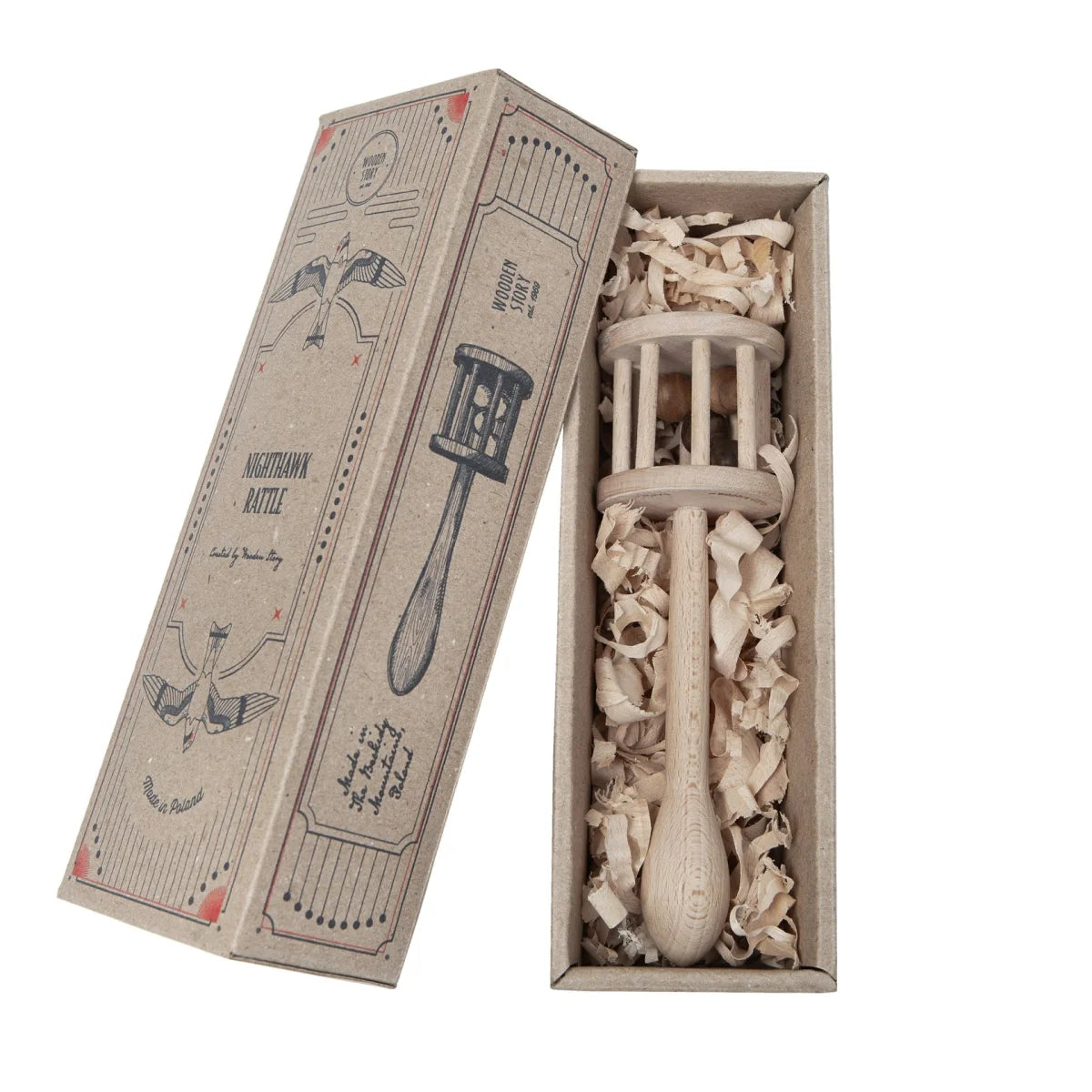 Eine rustikale weiße hölzerne rassel nighthawk mit spindelgriff und schlitzdeckel in einer box mit ökologische babyprodukte
