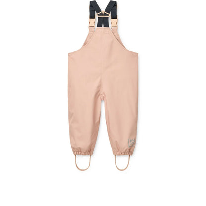 Beige wasserdichte overalls mit schwarzen verstellbaren trägern und hellen metallverschlüssen im regenbekleidungsset manu