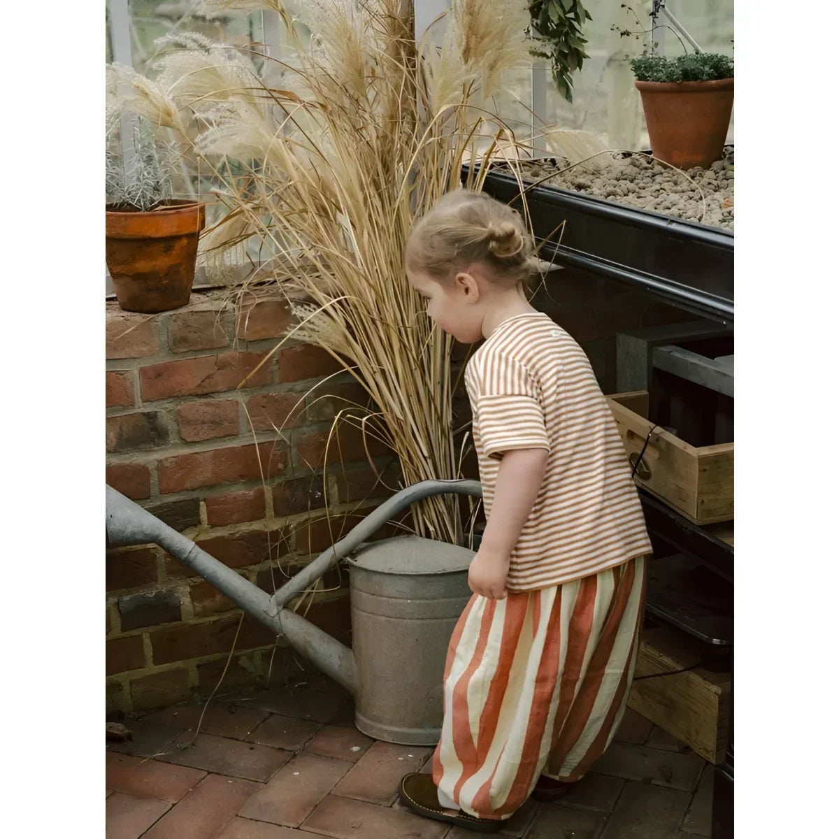 Kind mit Resort Pants Tomato Stripes in beige-orange Streifen