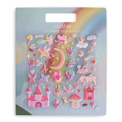 Mushie Reusable Sticker Set Feen mit pastellfarbenen Feen- und Einhorn-Stickern auf regenbogenfarbenem Hintergrund