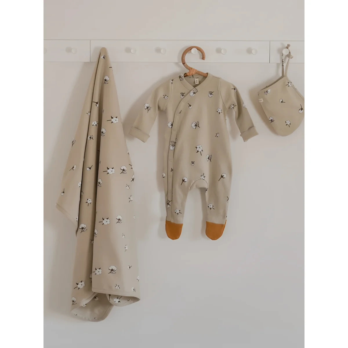 Beige Baumwoll-Babypyjama mit weißem Löwenzahn-Print und orangen Füßchen