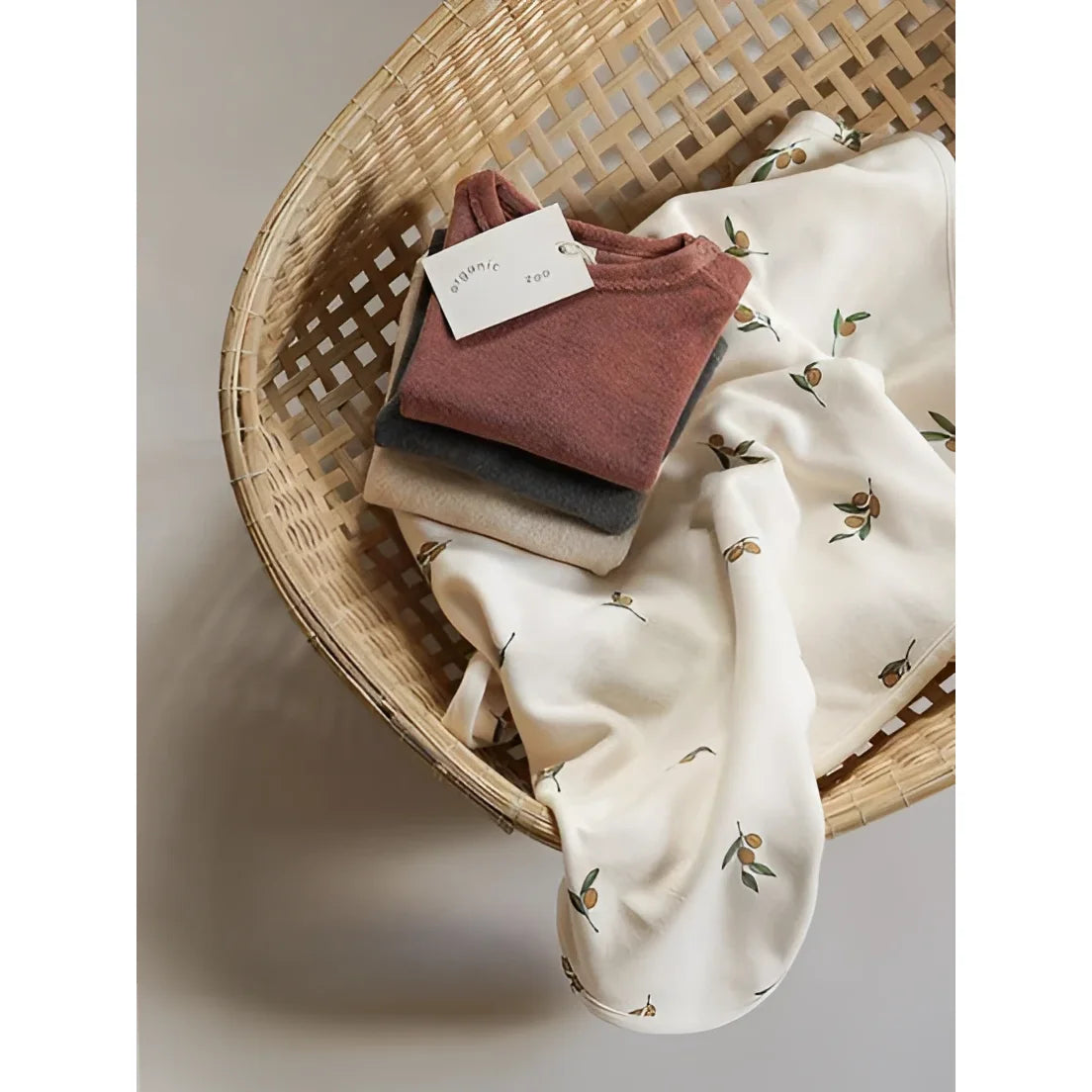 Weiche Stapel gefalteter Bio-Baumwoll-T-Shirts in Terrakotta, Beige mit Olivenblattmuster für Reversible Blanket Olive Garden