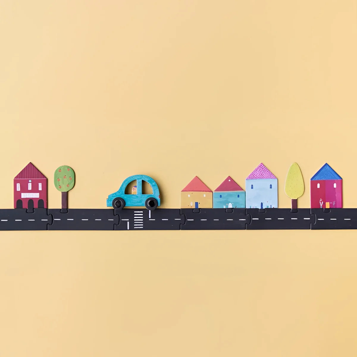 Bunte Papierschnittszene mit Häusern, Bäumen und einem Auto im Roads Game