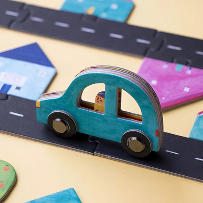 Teal wooden toy car on a black paper road from the Roads Game product line