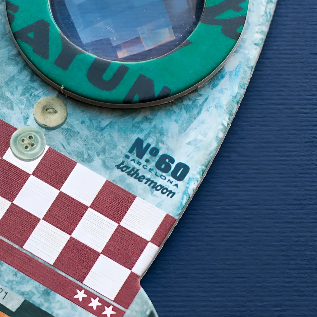 Teal kreisförmiger Rocket Bee Eye-Button mit schwarzer Schrift auf rot-weiß kariertem Patchwork