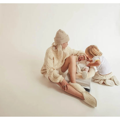 Familiengruppe in hellen Kleidung mit Schaffell-Booties in der Farbe Milch